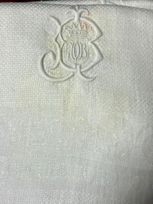 un gros plan sur une serviette blanche ornée d'un monogramme