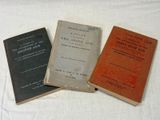three books sitting on top of a white table next to each other