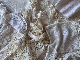 une pile de vêtements au crochet posée sur un lit