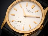 gros plan d'une montre-bracelet en or sur une surface noire