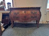 a dresser in the corner of a room with a clock on top of it