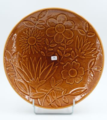 an image of a brown plate with flowers and leaves on it