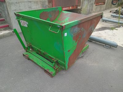 a green dumpster sitting in the middle of a parking lot