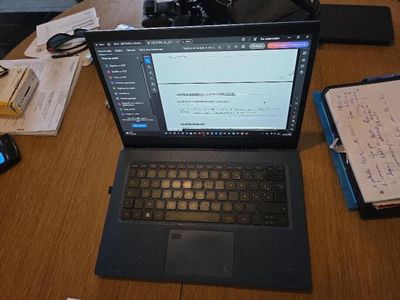 un ordinateur portable posé sur une table en bois