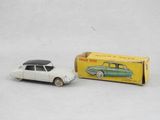 une image représentant une petite voiture et une boîte posées sur une surface blanche