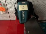 un sac à dos posé sur une étagère à côté d'une boîte