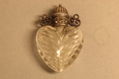 une photo d'un pendentif en forme de cœur surmonté d'une couronne