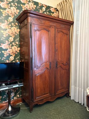 une grande armoire en bois dans un coin du salon