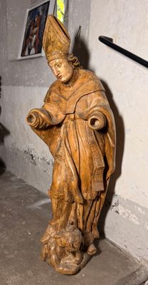 une statue représentant une femme tenant un livre dans une pièce