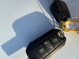 two keys attached to a car keychain on a white surface