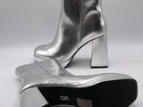 a close up of a pair of silver boots on a white surface