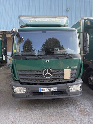un camion vert garé devant un immeuble