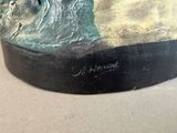 a statue of a man riding a wave on a surfboard