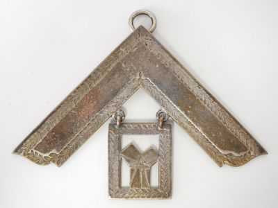 an image of a small metal object hanging from a white wall