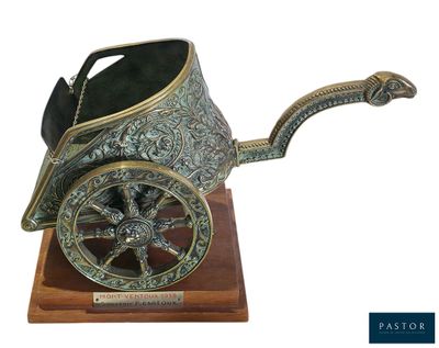 une calèche ancienne en métal argenté, posée sur un socle en bois