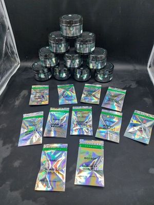 une pile de sachets en papier d'argent posée sur une table noire
