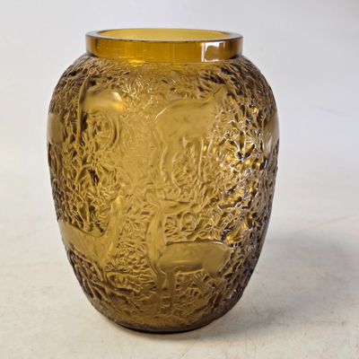 un vase en verre jaune orné d'un motif représentant un arbre