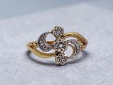 an image of a gold and diamond ring on a white surface