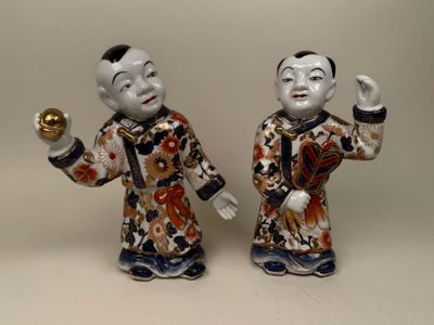 paire de figurines asiatiques représentant un homme et une femme tenant une boule dorée