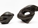 two pieces of art that are sitting on a white surface