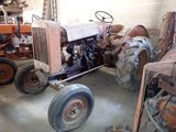 un tracteur qui est garé dans un garage avec d'autres tracteurs