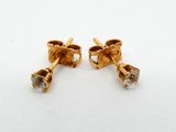 a pair of gold earrings with diamonds on a white surface