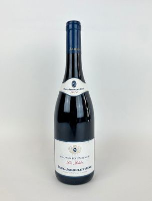 une bouteille de vin rouge posée sur une table blanche