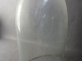 a clear glass bottle with a metal handle on a table