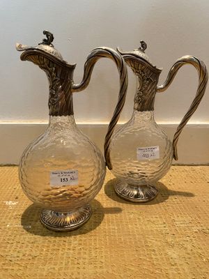 two glass vases sitting on a table next to each other