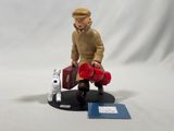 a figurine of a man with a suitcase and a dog