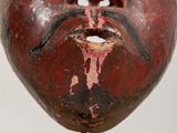 a close up of a wooden mask on a stand