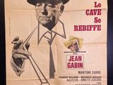 an old movie poster of a man in a hat and tie smoking a cigarette