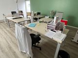 de nombreux bureaux et chaises dans une pièce dont l'un des murs est vert