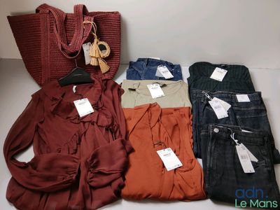 beaucoup de vêtements et un sac à main sur la table