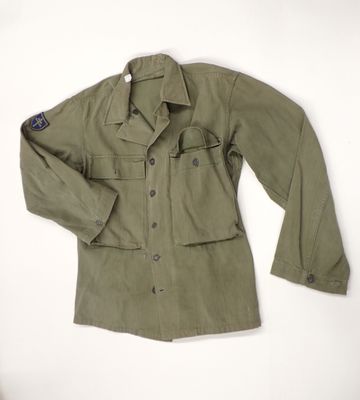 an army green jacket with a blue patch on the chest