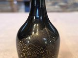 un vase noir posé sur une table dans une pièce