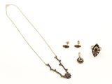 une photo représentant un collier, une boucle d'oreille et une bague posés sur un fond blanc