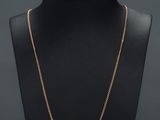 a gold chain necklace on a mannequin neck