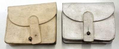 Deux petits étuis en cuir sont posés côte à côte sur une surface blanche.
