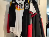 a black and white jacket and a red and black jacket hanging on a wall