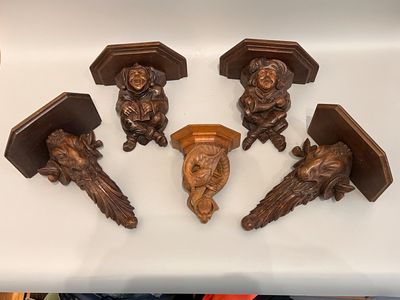 six figurines en bois sculpté posées sur un plan de travail blanc