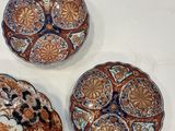 four decorative plates are arranged on a white surface