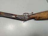 a close up of a rifle with a wooden handle on a table