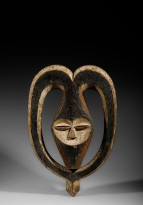 a close up of a wooden sculpture with a face on it