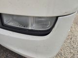 a close up of a car ' s headlight on the side of the road