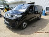 une photo d'une camionnette noire garée devant un immeuble
