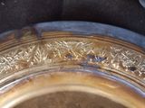 a close up of a silver plate with a flower design on it