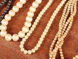 a lot of pearls that are on a wooden table