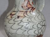 a white vase with brown designs on it on a table