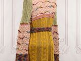 a mannequin dress with multicolored knits on a mannequin stand